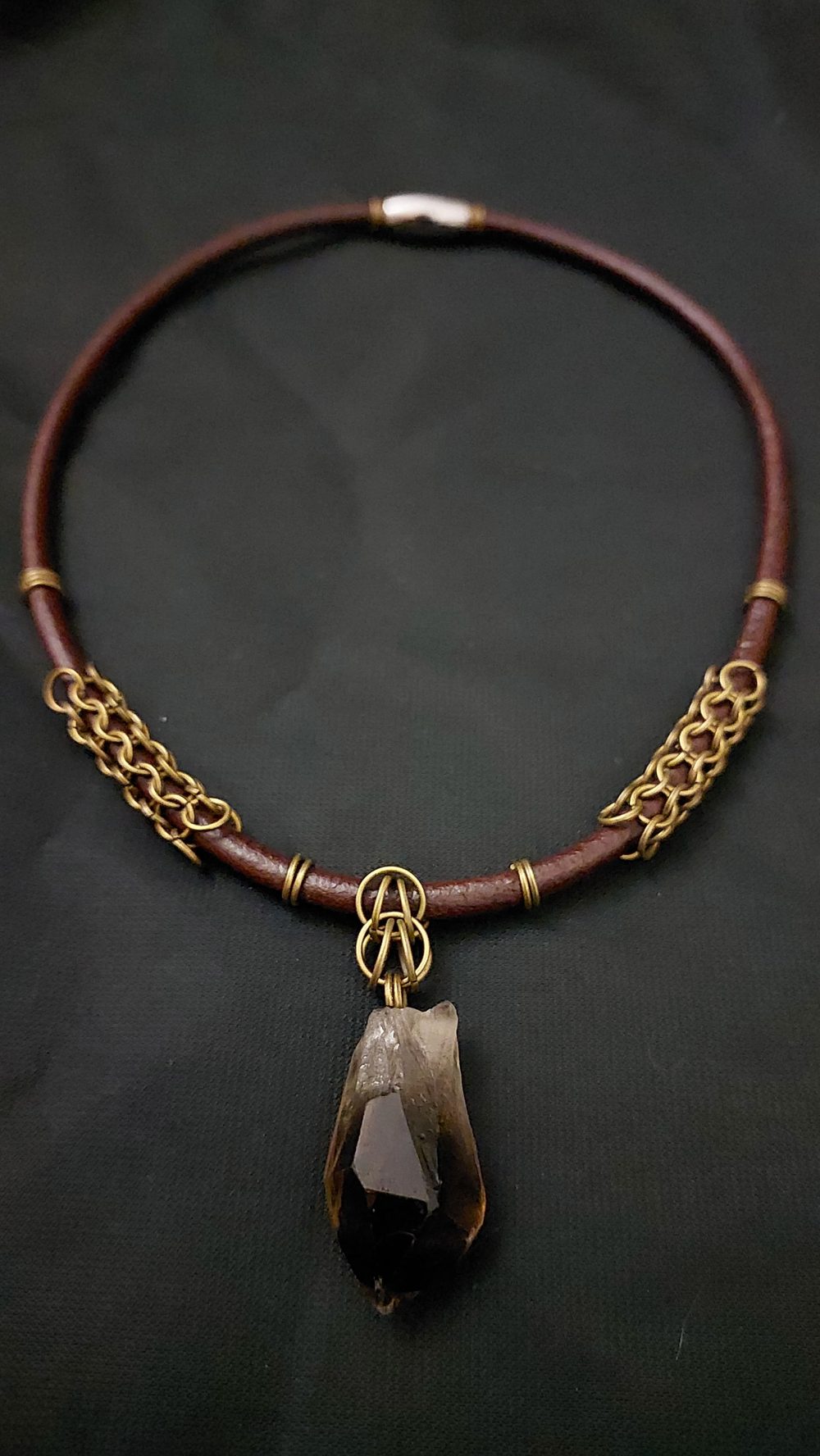 Collar de cuero café con malla de argollas doradas y una punta de cuarzo en bruto